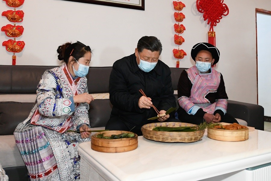 2021年2月3日下午，習(xí)近平在貴州畢節(jié)市黔西縣新仁苗族鄉(xiāng)化屋村苗族村民趙玉學(xué)家，同一家人邊聊家常邊制作當(dāng)?shù)貍鹘y(tǒng)節(jié)日食品黃粑。新華社記者 李學(xué)仁 攝